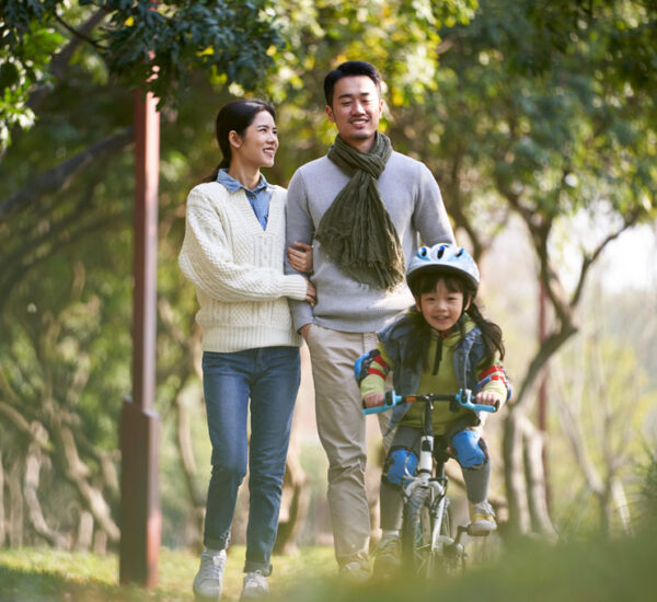 Photo of a young couple and their child riding a bike