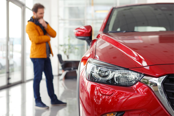 Image of a man looking at a new car in a dealership