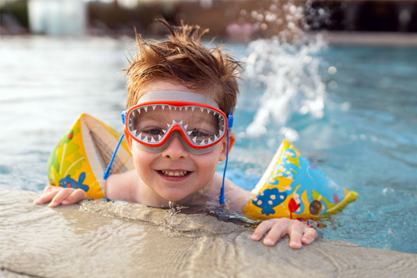 Image of a happy child swimming in a pool